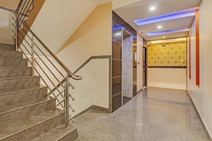 A staircase with metal railings leading to a landing. - Capital O Champion Lotus  (Bangalore)