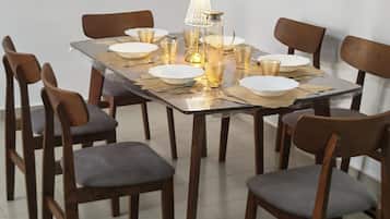 Una mesa de comedor dispuesta con platos, vasos y una lámpara.