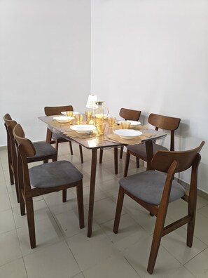 A dining table with chairs, a lamp, and glassware. - Palm Court Kuantan (Kuantan)