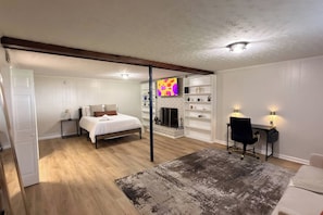 Una camera da letto con un letto, una televisione, un camino e una scrivania con una sedia.