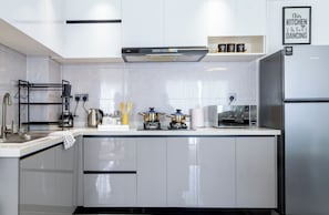 A modern kitchen with white cabinetry, a stainless steel refrigerator, a coffee machine, and a gas stove. - 1-bedroom Apartment With Nairobi National Park Views (Syokimau)