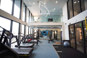 A gym with cardio equipment, weight machines, and a mirrored wall. - Modern J-Town Townhome | Bright & Stylish (San Jose)