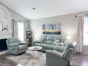A living room with a sectional sofa, two armchairs, a coffee table, and a fireplace. - A Place To Imagine! Minutes From Atlanta, GA! (Norcross)