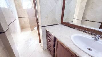 A bathroom with a sink, mirror, and wooden cabinet.
