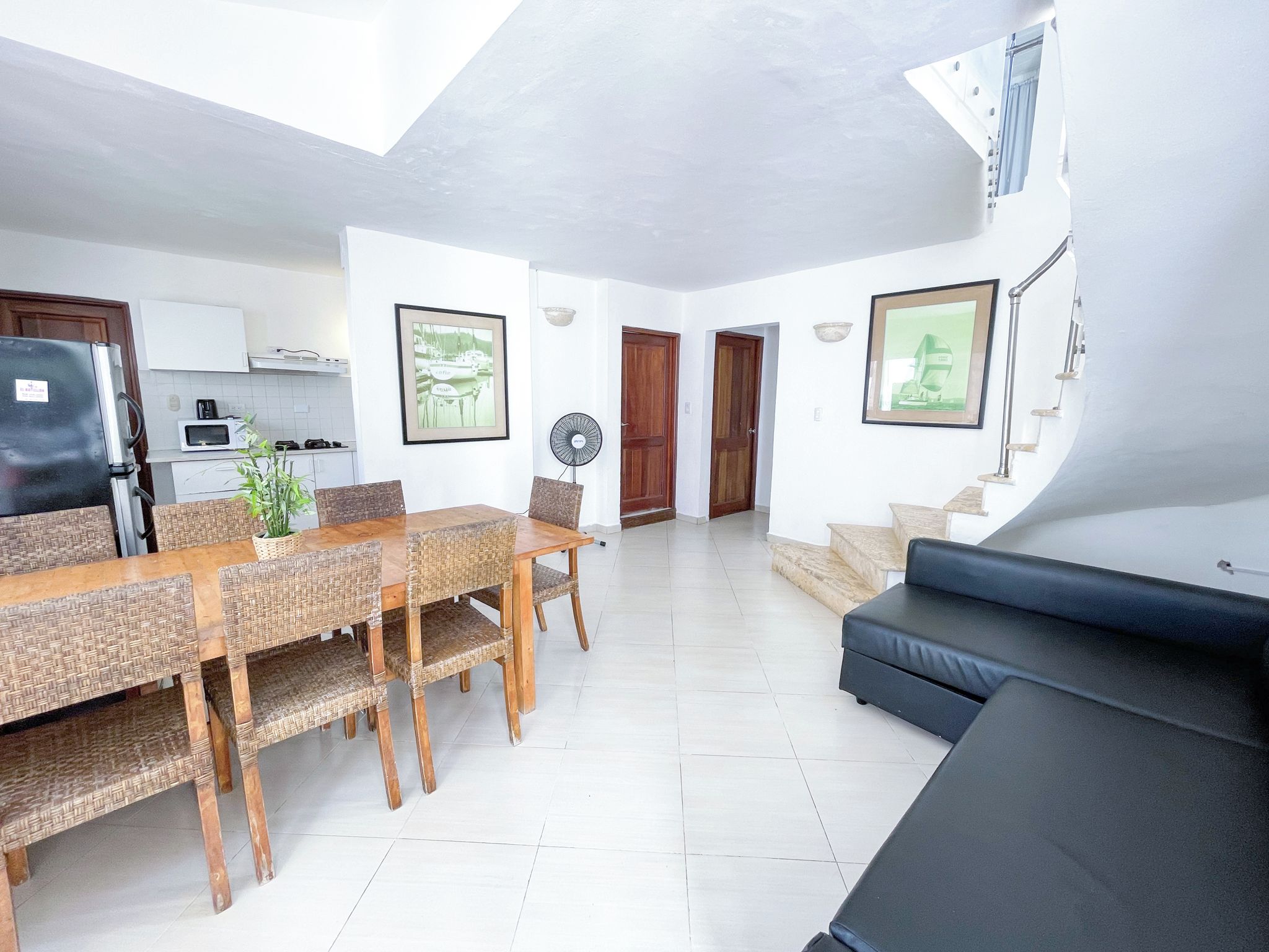 A modern living space with a dining area, kitchen, and seating area.