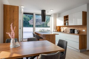 Una cocina moderna con una isla de madera, armarios blancos y vistas al exterior.