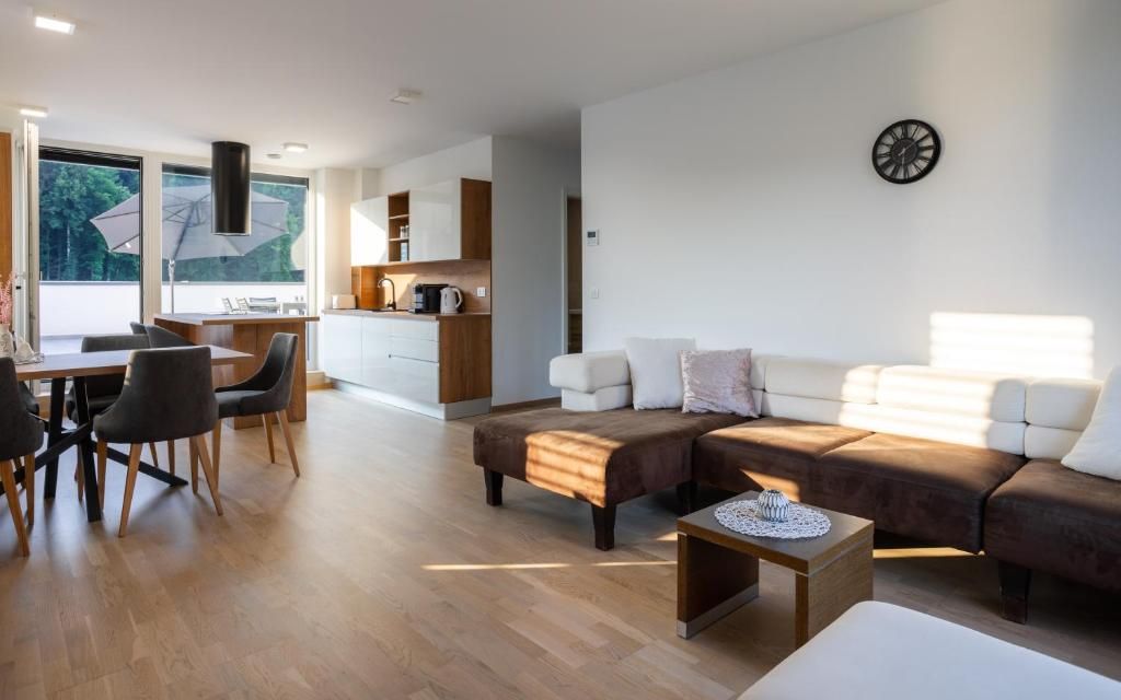 A modern living room with a sofa, coffee table, and dining area.