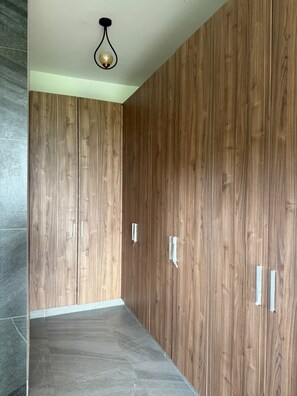 A room with a wooden wardrobe, a light fixture, and a tiled floor. - Spacious Home 4BR with Pool in Pachacamac (Lurín)