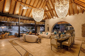 A spacious outdoor dining area with a thatched roof, modern furniture, and a view of the landscape. - Skypool. Luxury mansion with staff, chef and waiter included. (Ixtapa Zihuatanejo)