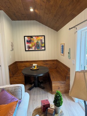 Eine Sitzecke mit runden Tisch, einer Bank und einem kleinen Blumentopf.