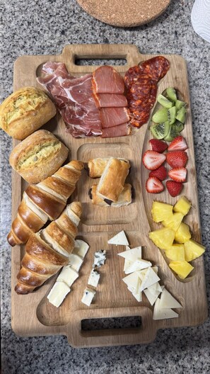 A wooden board with various food items including bread, cheese, fruits, and meats. - Country house between the sea and the mountains—pets welcome!—with direct access to the beach (Caravia)