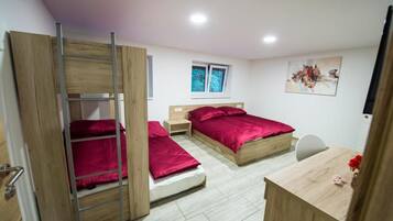 A bedroom with a bunk bed, a desk, and a chair.