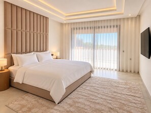 Habitación de hotel moderna con una cama grande, un televisor de pantalla plana y vistas al exterior.