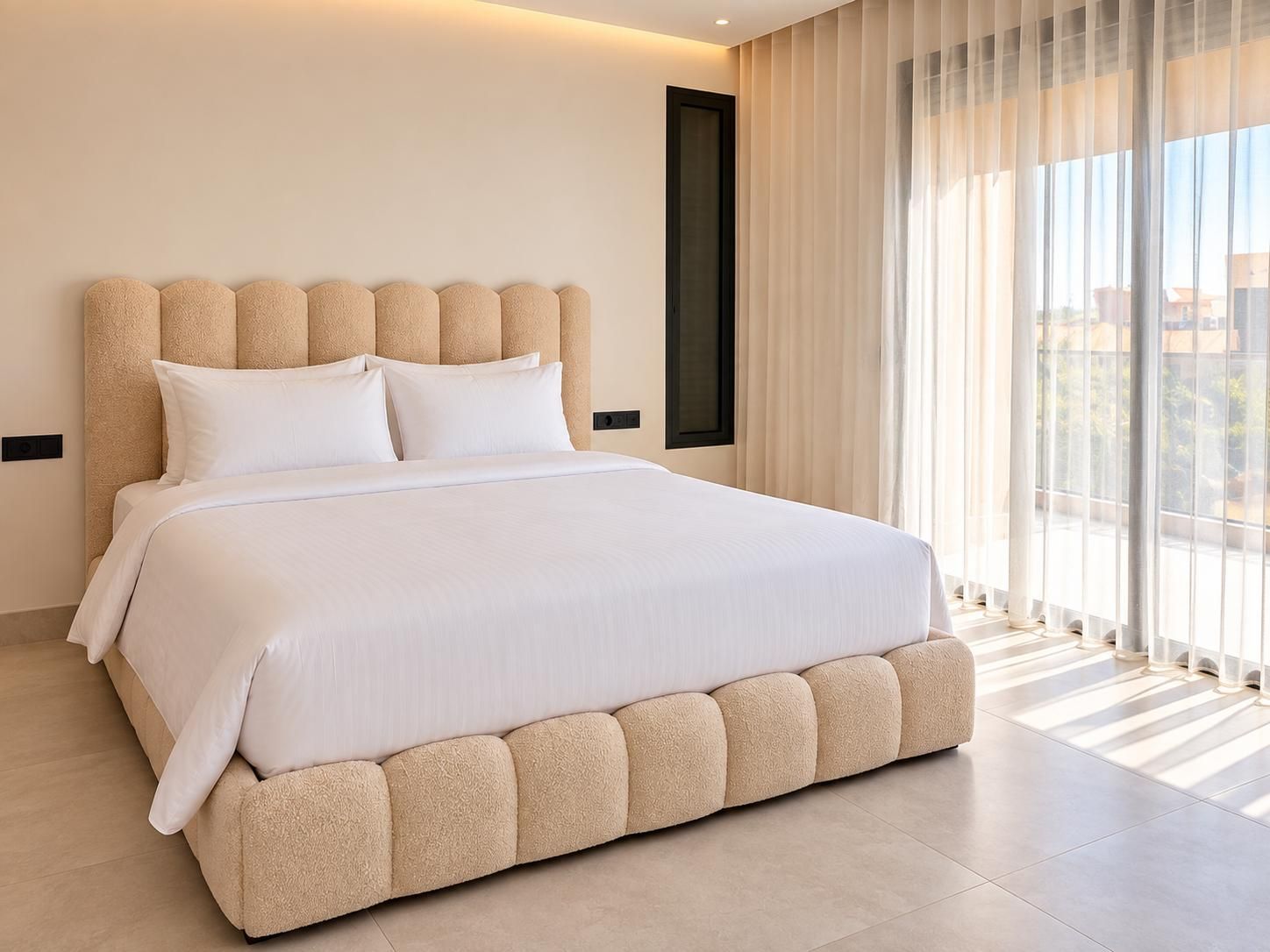 A modern bedroom with a large bed, a headboard, and a window with curtains.