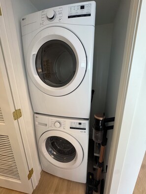 Una lavadora y secadora apiladas en un cuarto de lavado.