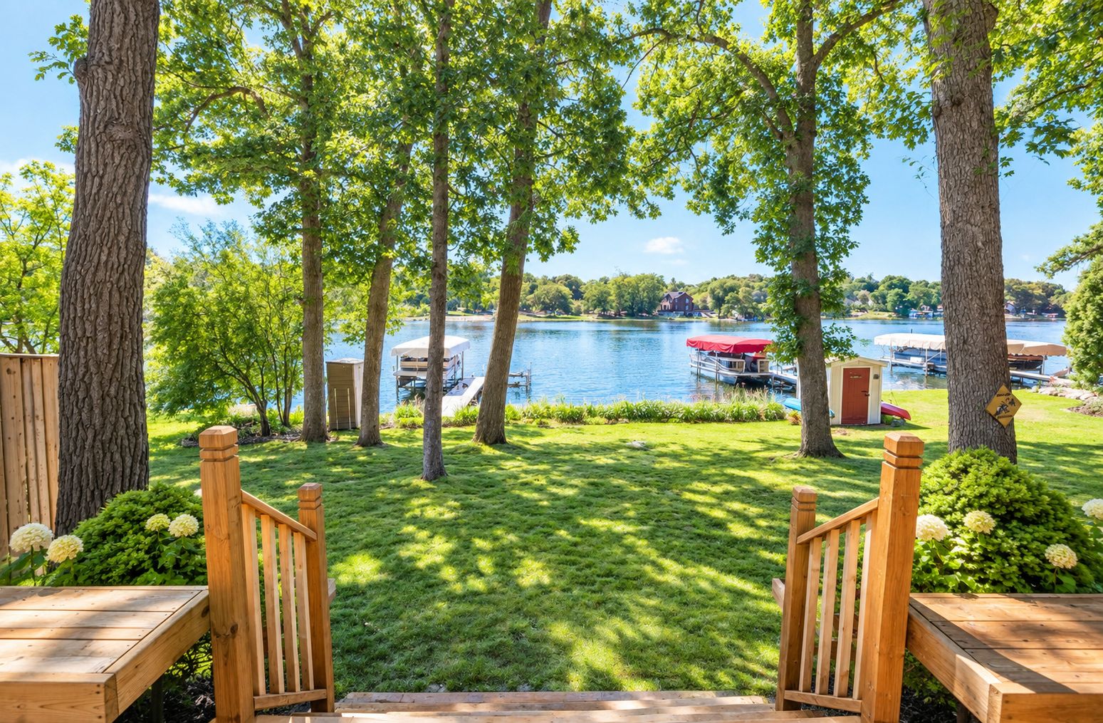 A wooden deck with a view of a lake and docked boats.