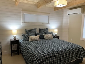 A bedroom with a bed, two bedside tables, a window, and a ceiling light fixture. - A Cozy suite near Seven Springs Mountain Resort  (Champion)