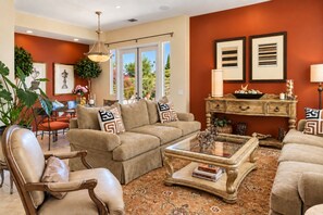 A living room with a beige sofa, a glass coffee table, and a patterned rug. - Serene 2-bedroom house with Private Pool & Jacuzzi in Rancho Mirage (Rancho Mirage)