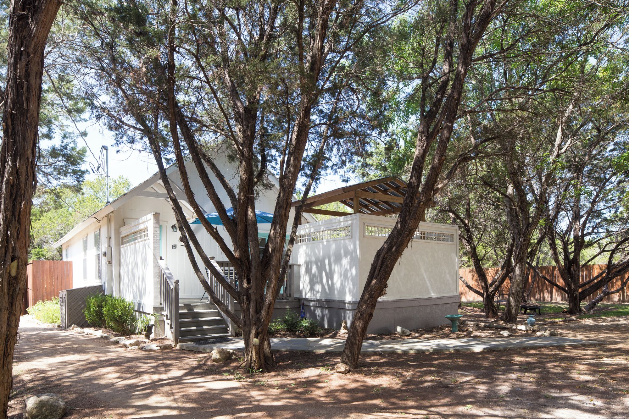 A single-story building with a porch, surrounded by trees.
