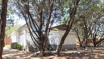 A single-story building with a porch, surrounded by trees.