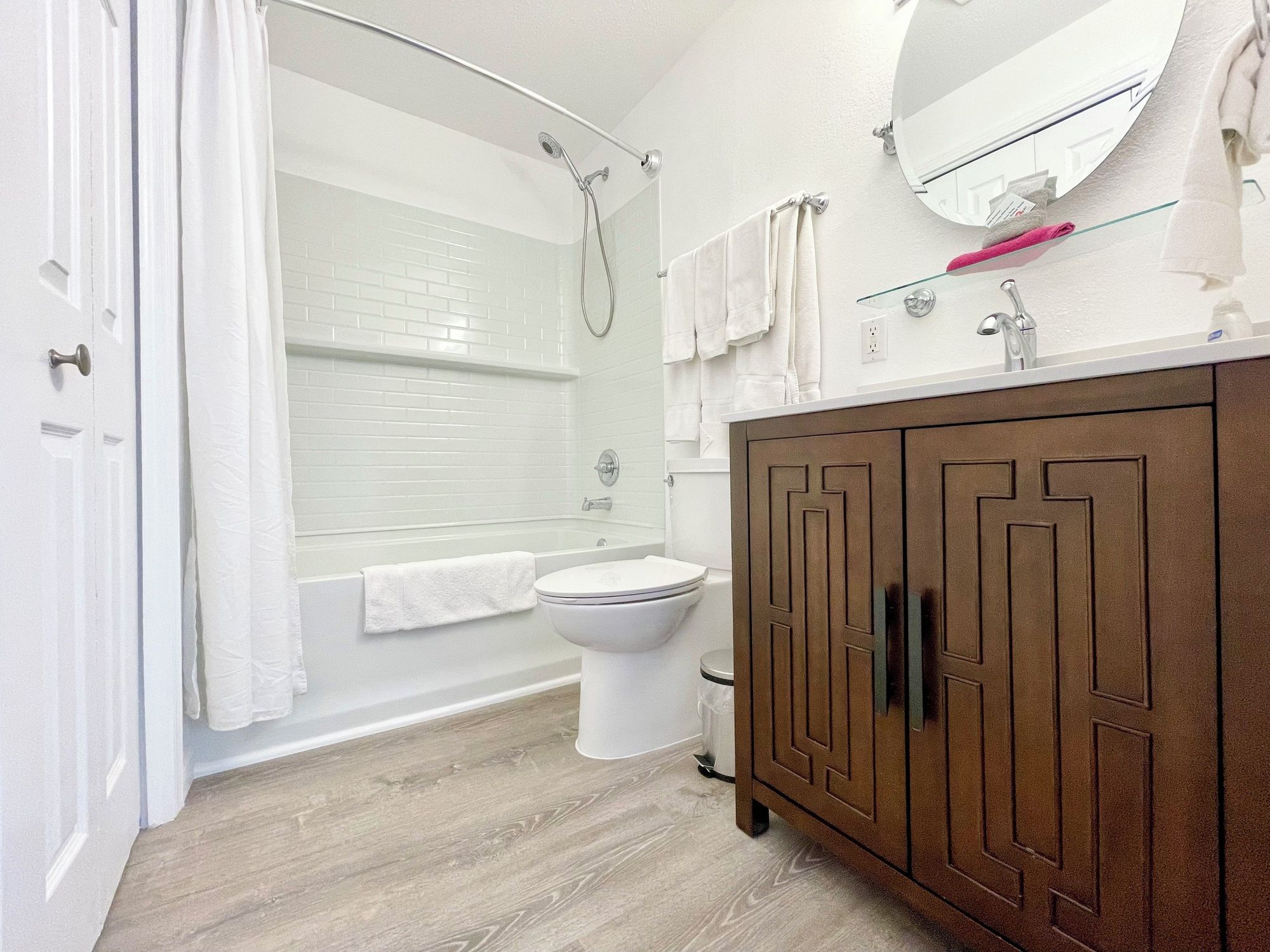 A modern bathroom with a shower, toilet, and vanity.