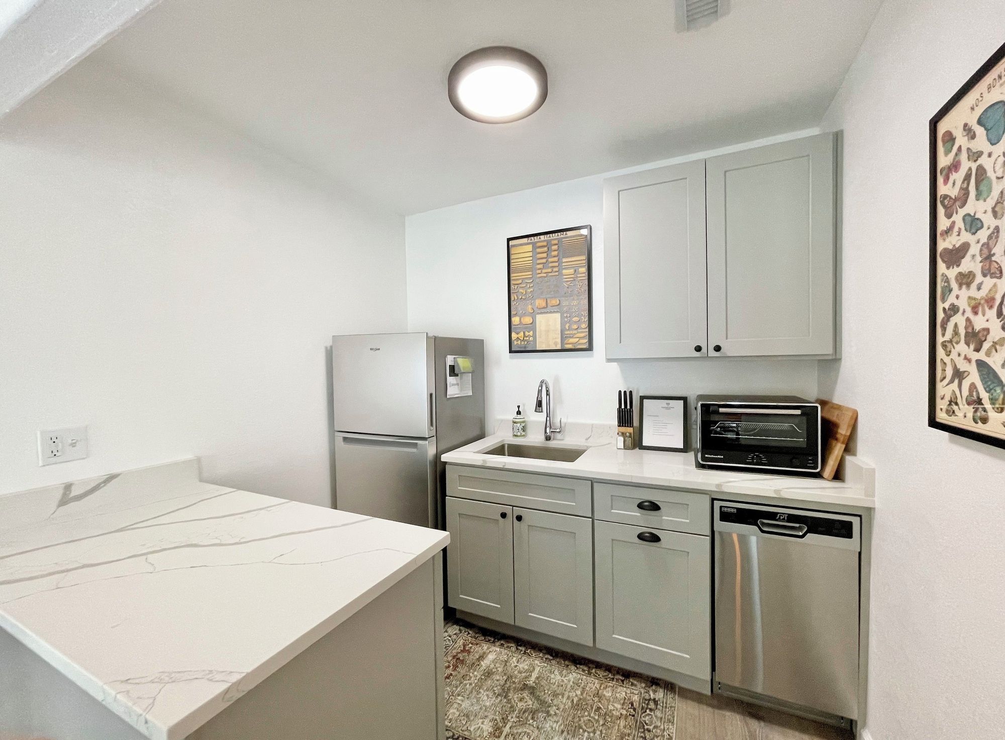 A compact kitchen with a refrigerator, microwave, and dishwasher.