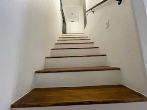 A staircase with wooden steps leading to a landing. - Cottage 8 Black, Pet-Friendly One-Bedroom Cottage with Loft, Hot Tub (Wimberley)