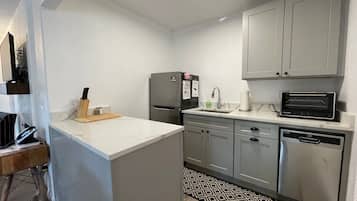 A compact kitchen with a refrigerator, microwave, and dishwasher.