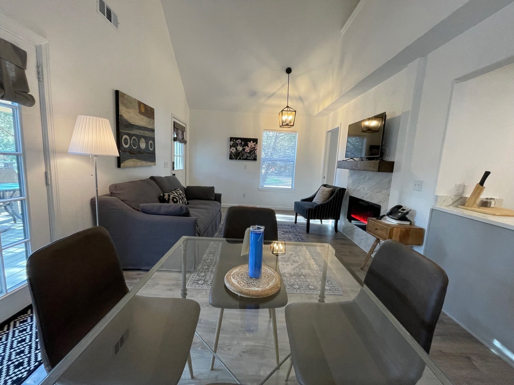 A modern living room with a dining table, sofas, and a fireplace.