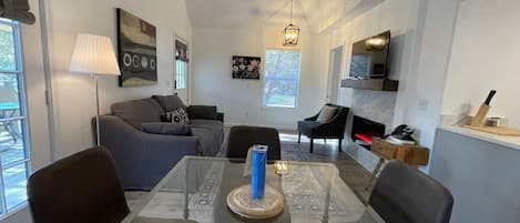 Una sala de estar moderna con una mesa de comedor, sofás y una chimenea.