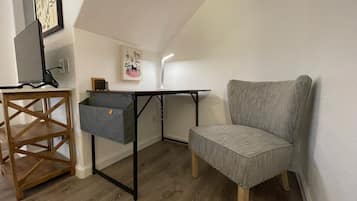 A compact room with a desk, chair, and storage unit.