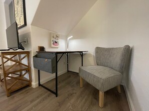 A compact room with a desk, chair, and storage unit. - Cottage 8 Black, Pet-Friendly One-Bedroom Cottage with Loft, Hot Tub (Wimberley)