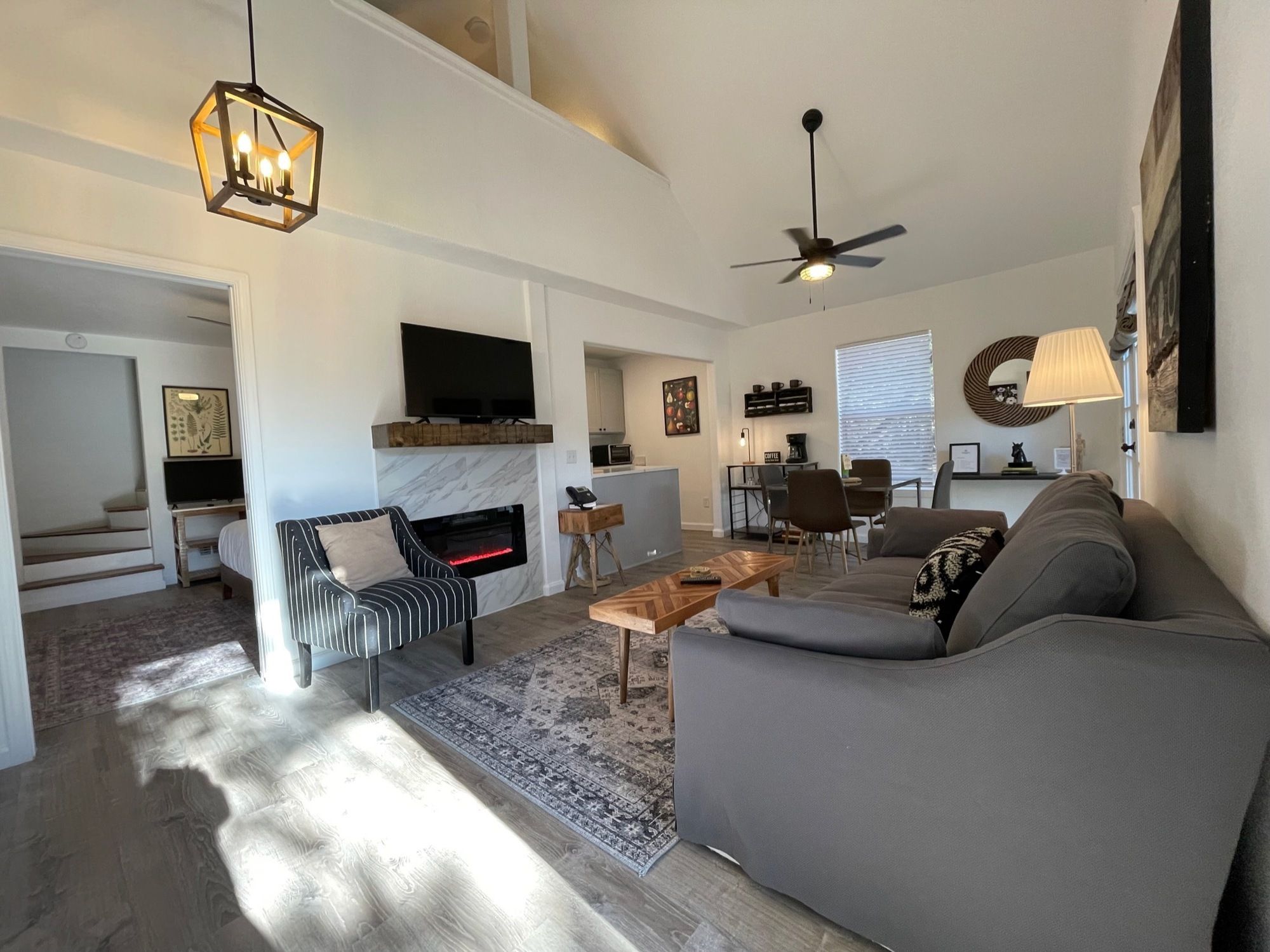 Una sala de estar moderna con chimenea, un sofá, una mesa de centro y un televisor.