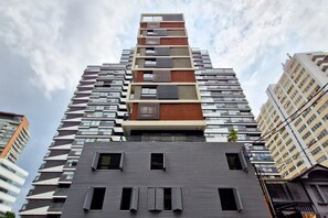A modern high-rise building with a unique stepped design, featuring balconies and large windows. - Blend Oscar Freire By Housi (São Paulo)