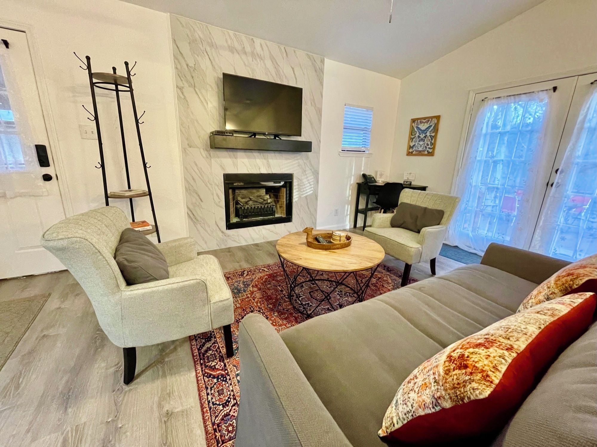 A modern living room with a fireplace, a television, and a sofa.