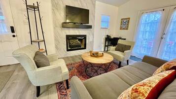 A modern living room with a fireplace, a television, and a sofa.