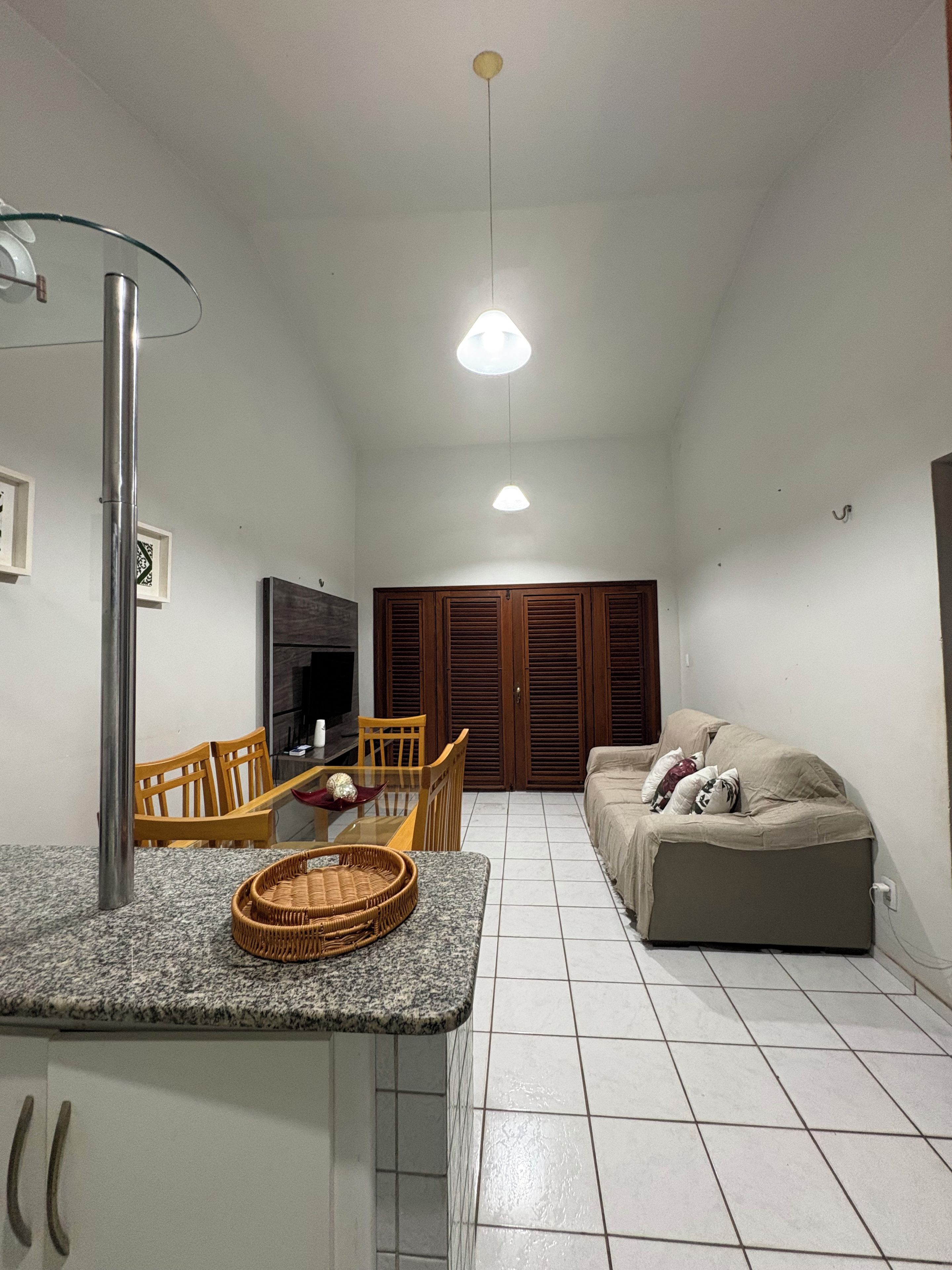 A compact living space with a kitchenette, a dining area, and a seating area with a sofa.
