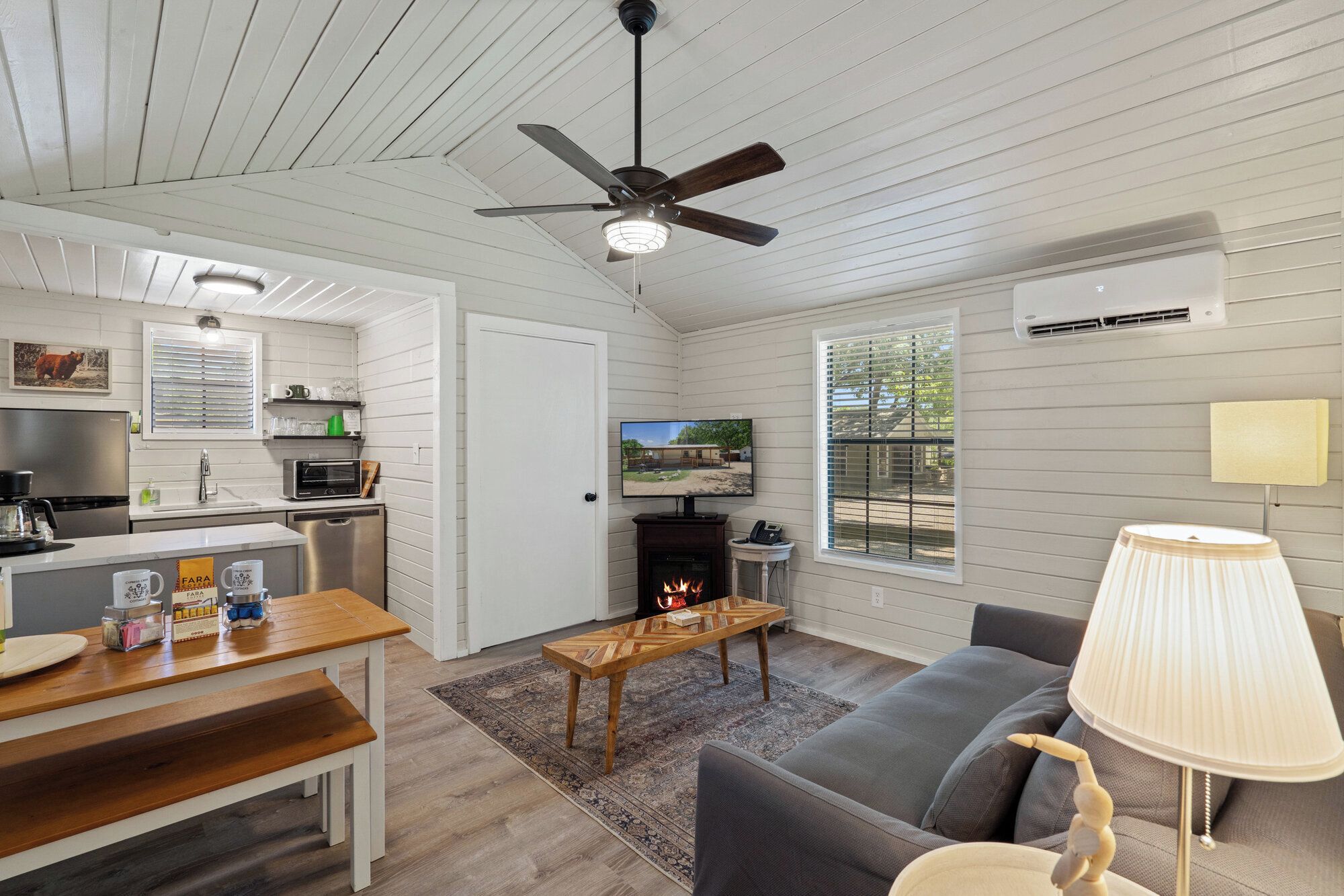 A modern living space with a kitchen, dining area, and seating area.