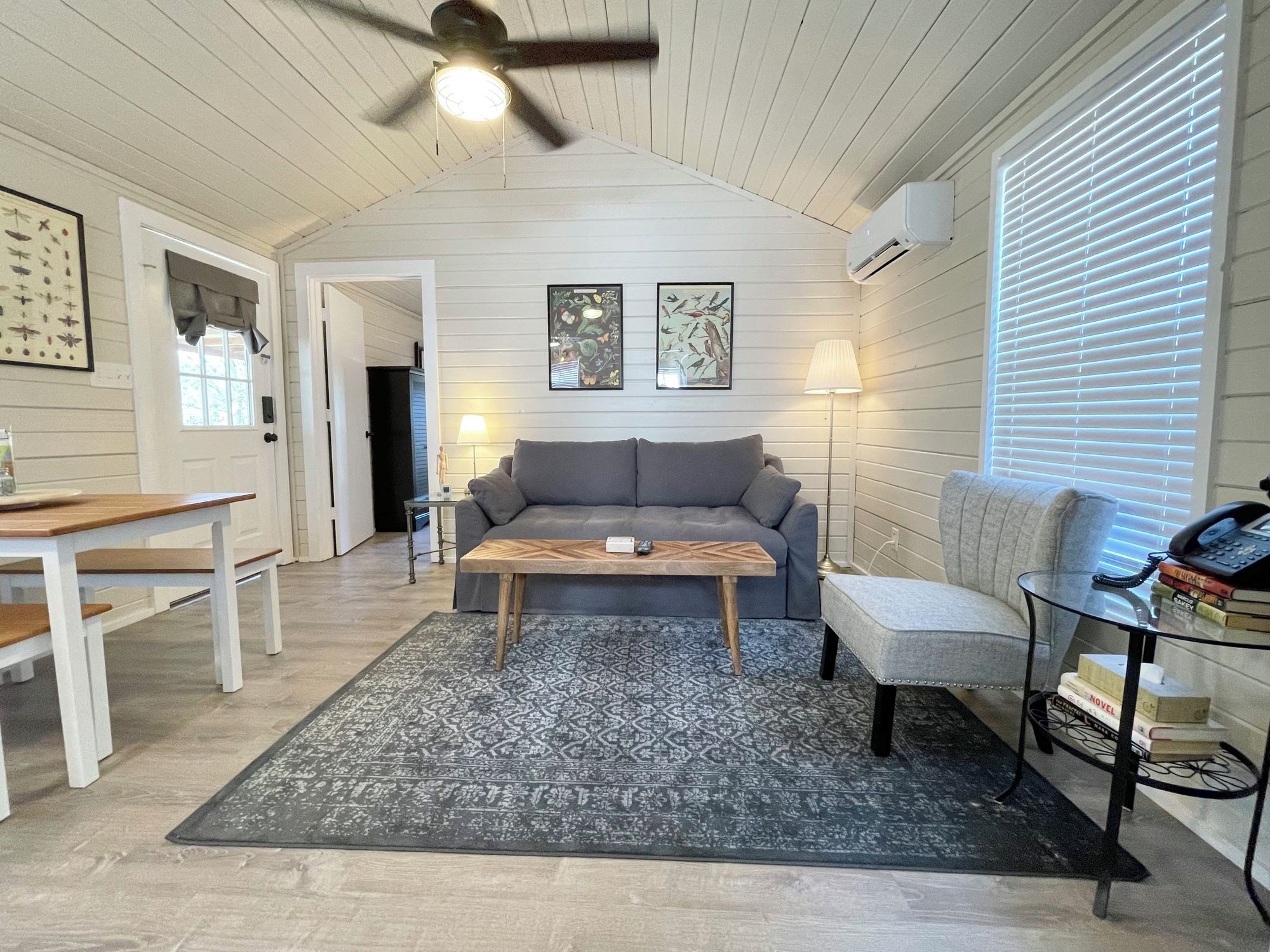 A cozy living room with a sofa, coffee table, and a side table with books.