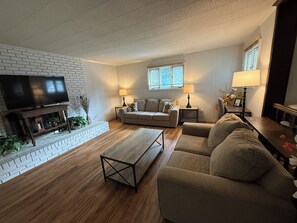 A living room with a television, two couches, a coffee table, and a fireplace. - GUNILLA's VILLA - The heart of downtown with privacy near LAKE NORMAN (Mooresville)