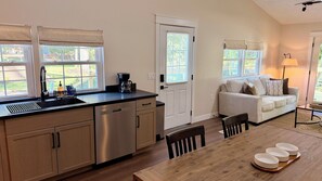 A modern kitchen with a dining area, a sofa, and a lamp. - "The Wilson Cabin" Cozy Accommodation on the River (Norfork)