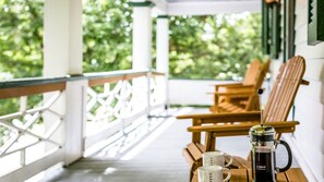 En træterrasse med to stole og en kaffemaskine på et bord.