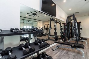 A gym with weightlifting equipment, dumbbells, and a mirror. - Stylish Mesa 2BR • Perfect for ASU Visits (Mesa)