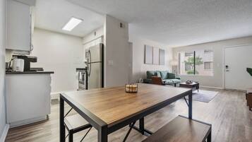 Un apartamento moderno con comedor, kitchenette y sala de estar.