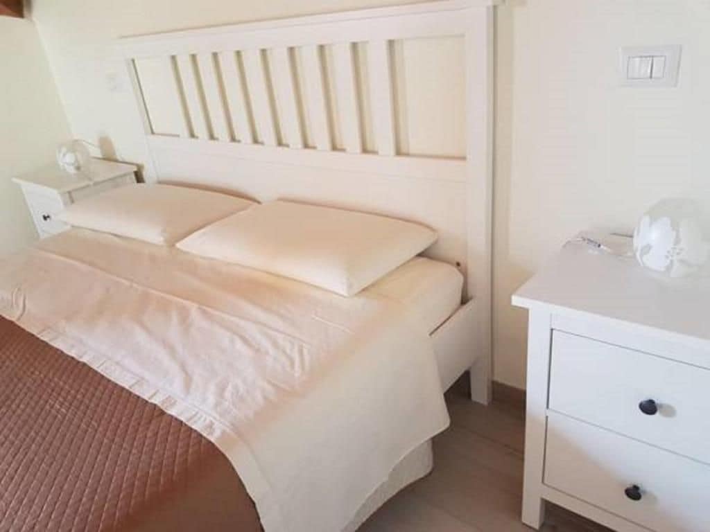Une chambre à coucher avec un lit, une table de chevet et une commode.