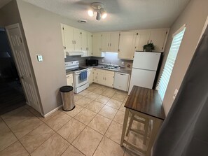 A kitchen with white cabinets, a stove, a sink, and a refrigerator. - Cozy Rome Condo - Full Kitchen - Washer/Dryer -Great for Work Stays (Rome)