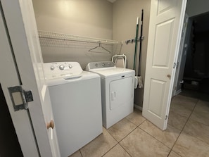 A laundry area with two washing machines, a drying rack, and a mop. - Cozy Rome Condo - Full Kitchen - Washer/Dryer -Great for Work Stays (Rome)