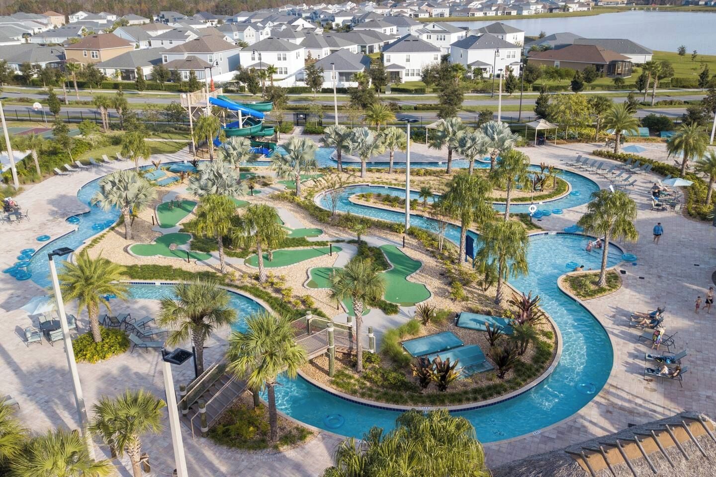 A resort with a large pool area, multiple water slides, and a golf course.