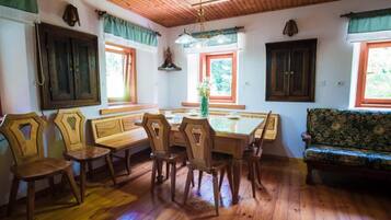 Un comedor con una mesa y sillas de madera, un banco y un sofá.
