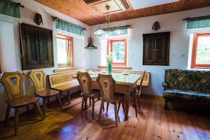 Un comedor con una mesa y sillas de madera, un banco y un sofá.